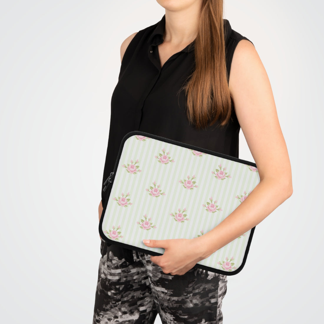 Person holding a floral patterned clutch bag against a white background