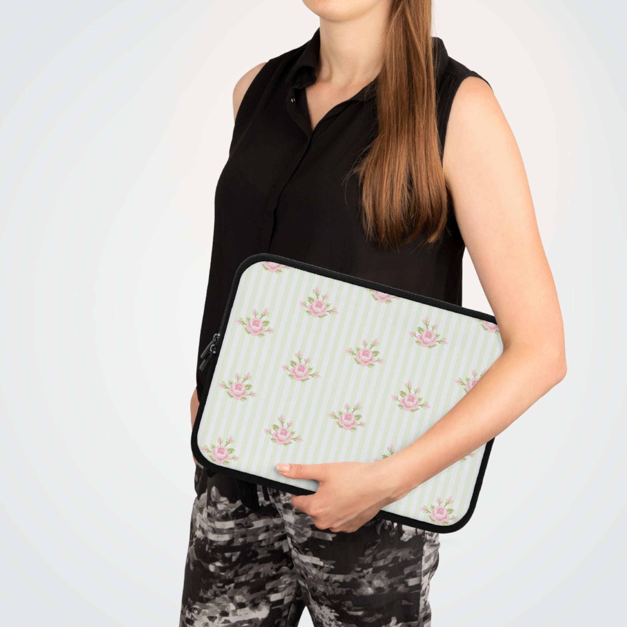 Person holding a floral patterned clutch bag against a white background