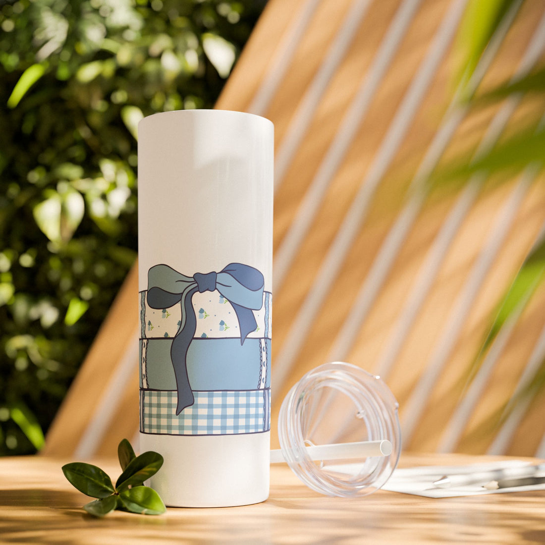 White tumbler with blue book design and a blue coquette bow.