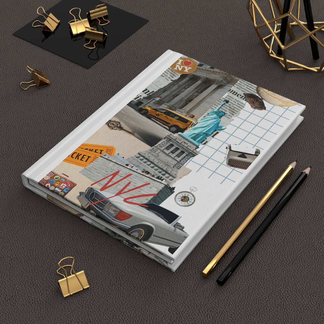Notebook with New York City-themed cover on a dark surface with stationery items.