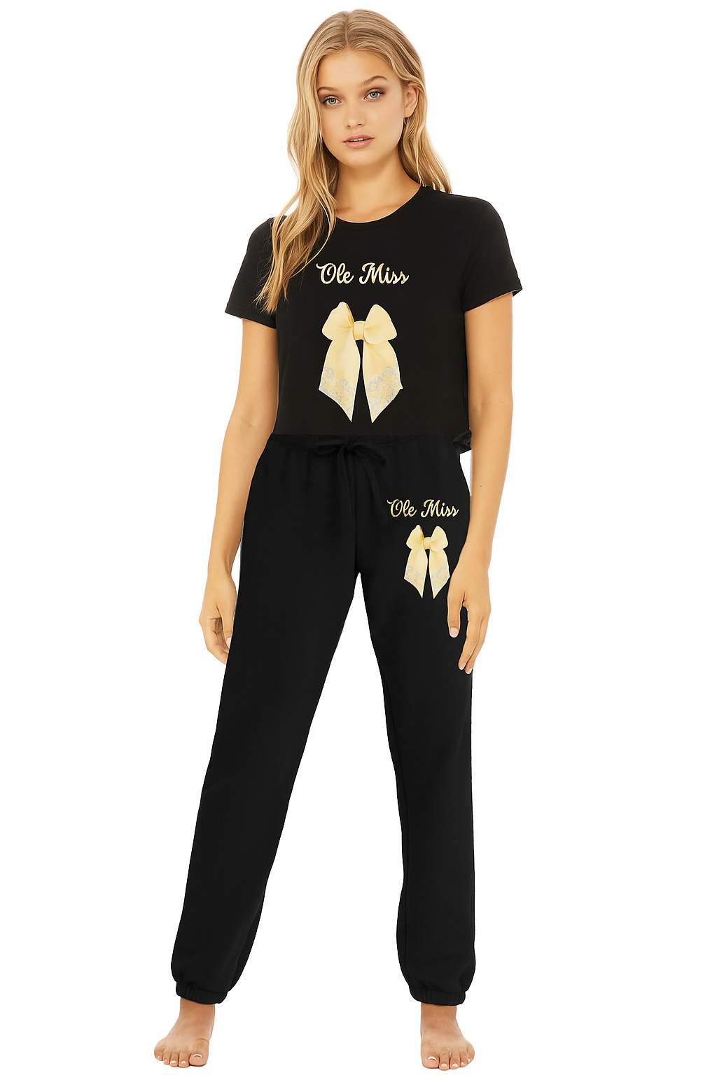 Woman wearing a black 'Ole Miss' themed pajama set with gold bows on a white background