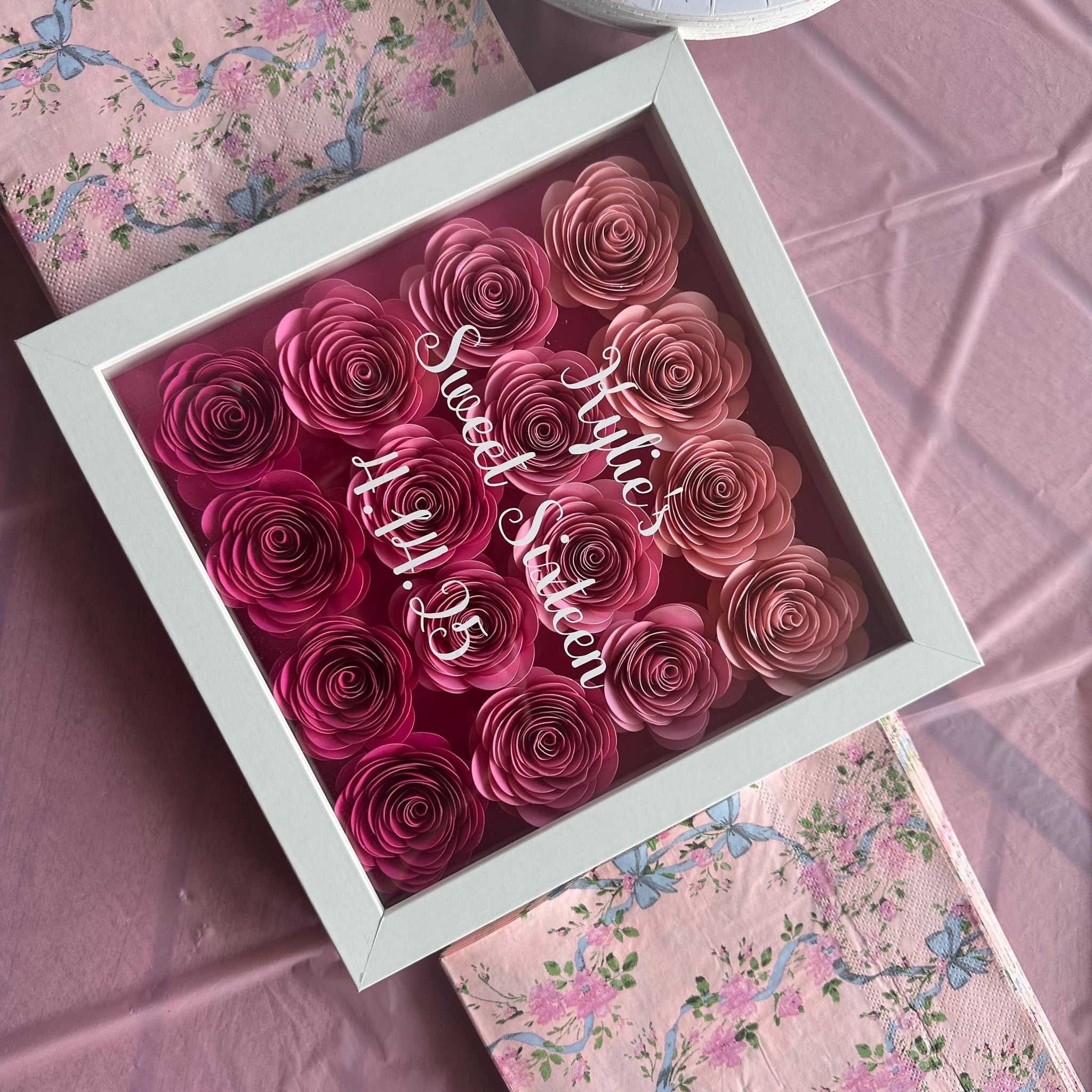 Flower shadow box with ombre pink roses with Kylie's sweet 16 written on top.