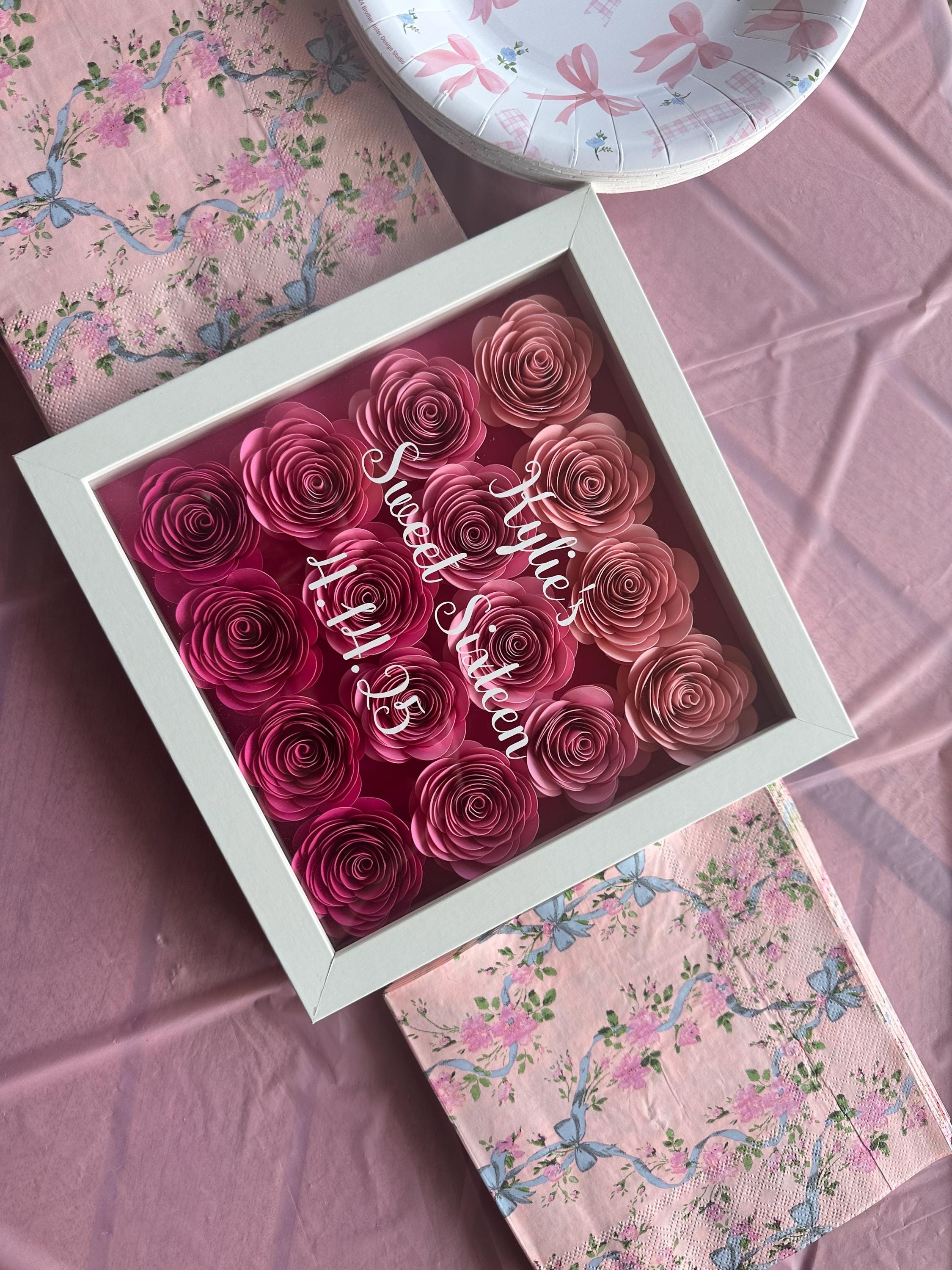Flower shadow box with ombre pink roses with Kylie's sweet 16 written on top.