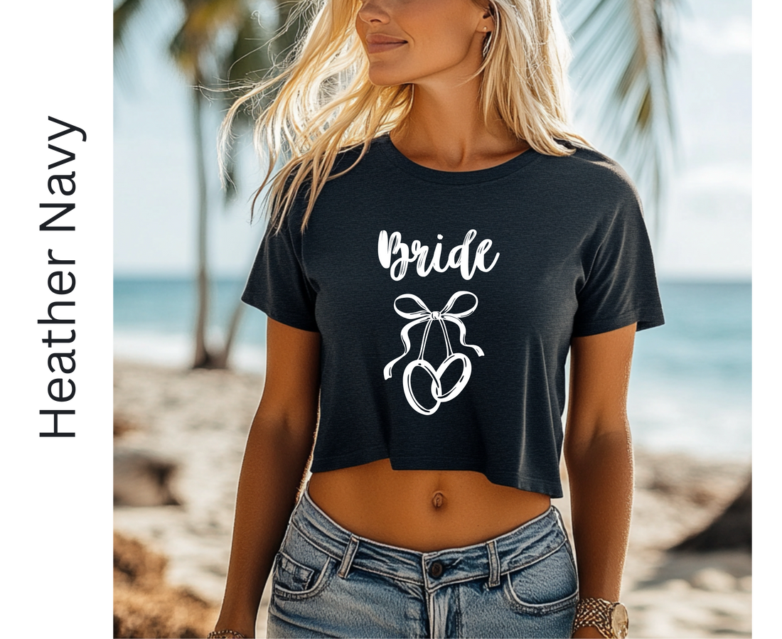 Woman wearing a black 'Bride' t-shirt with a bow graphic on a beach.