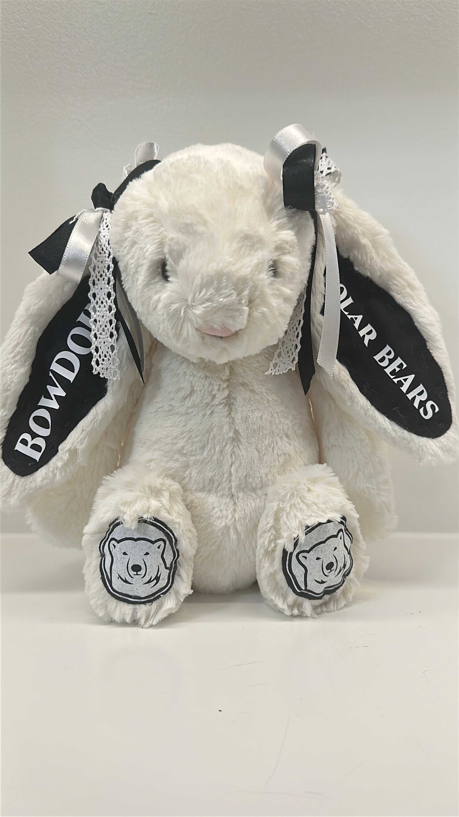 White plush bunny with black accents and 'Bowdoin College
' branding on a white background