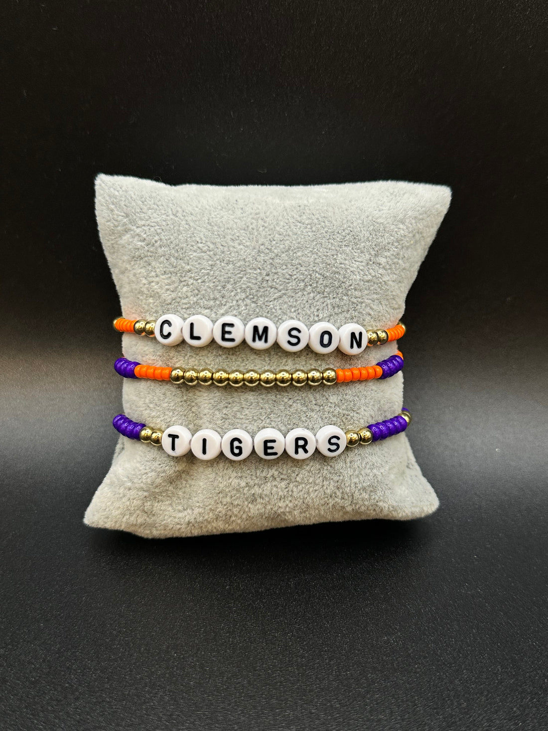 Three beaded bracelets with 'Tigers' and 'Clemson' text on a marble surface