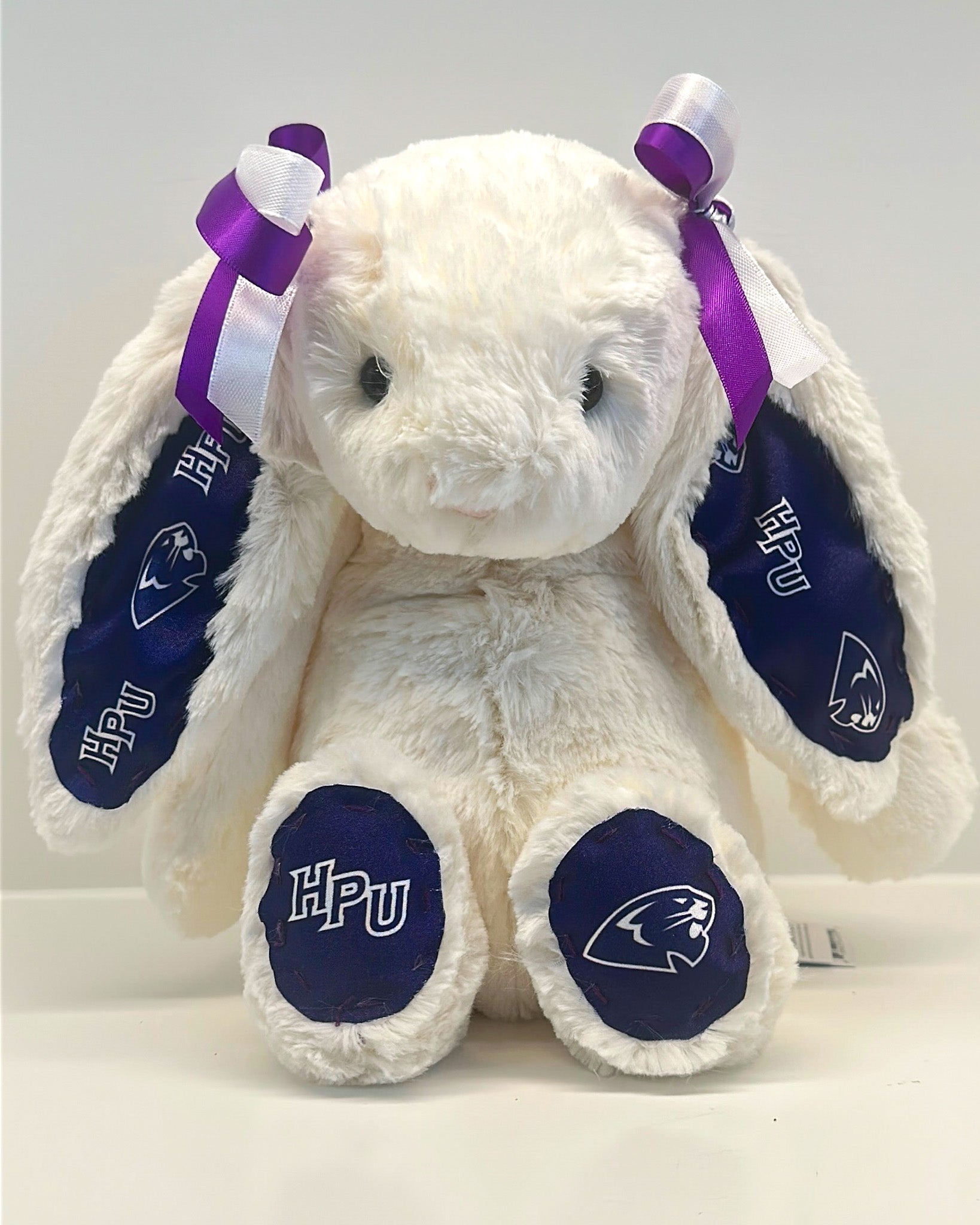White plush bunny with purple ears and HPU logo on a white background