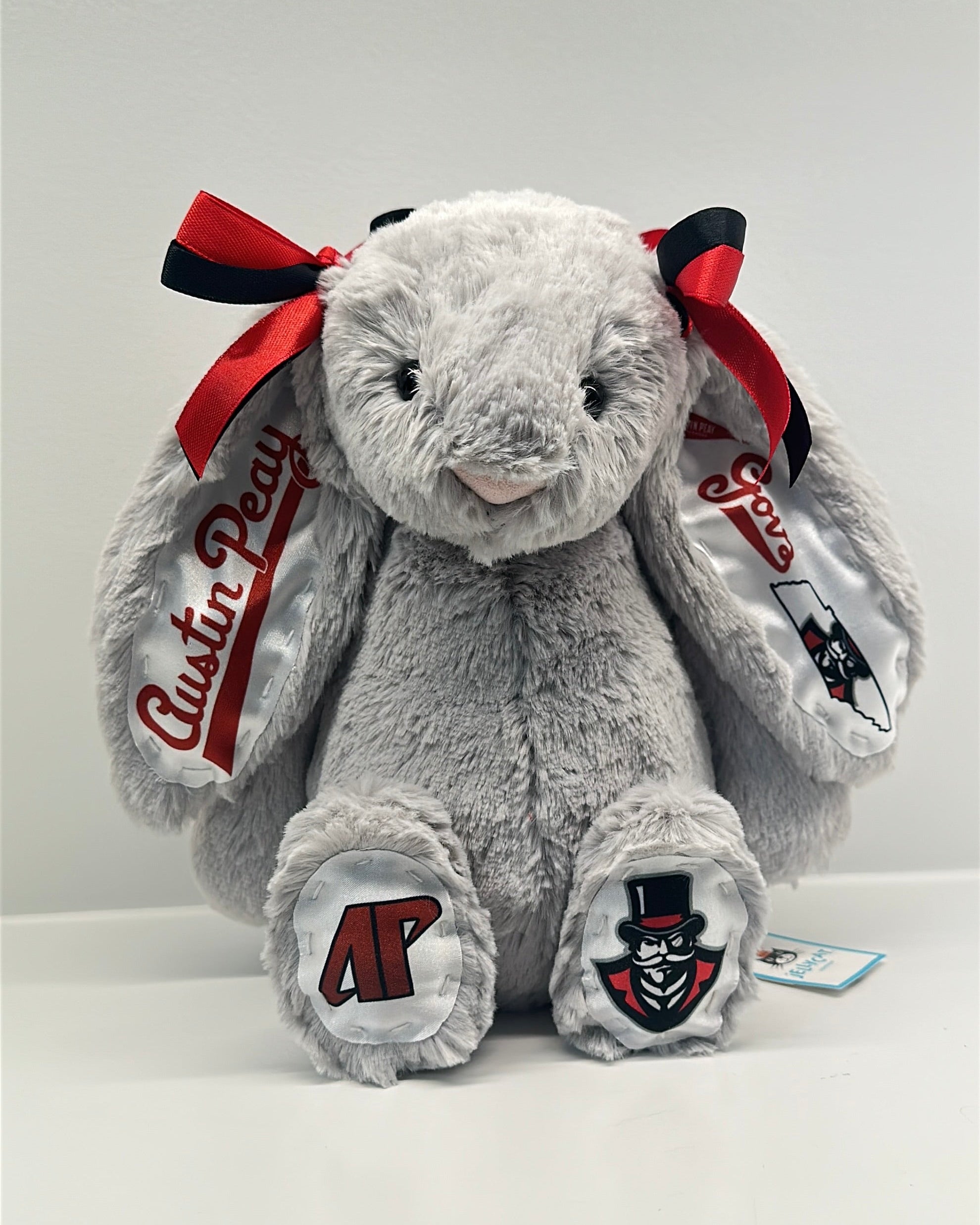 Gray plush bunny with red bows and 'Austin Peay' branding on a white background