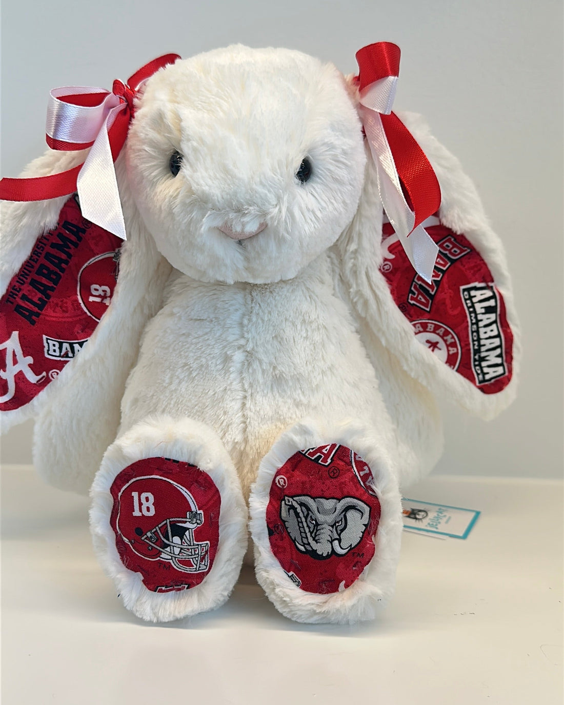 White stuffed bunny with red and black accents and a heart-shaped tray on a white background alabama university