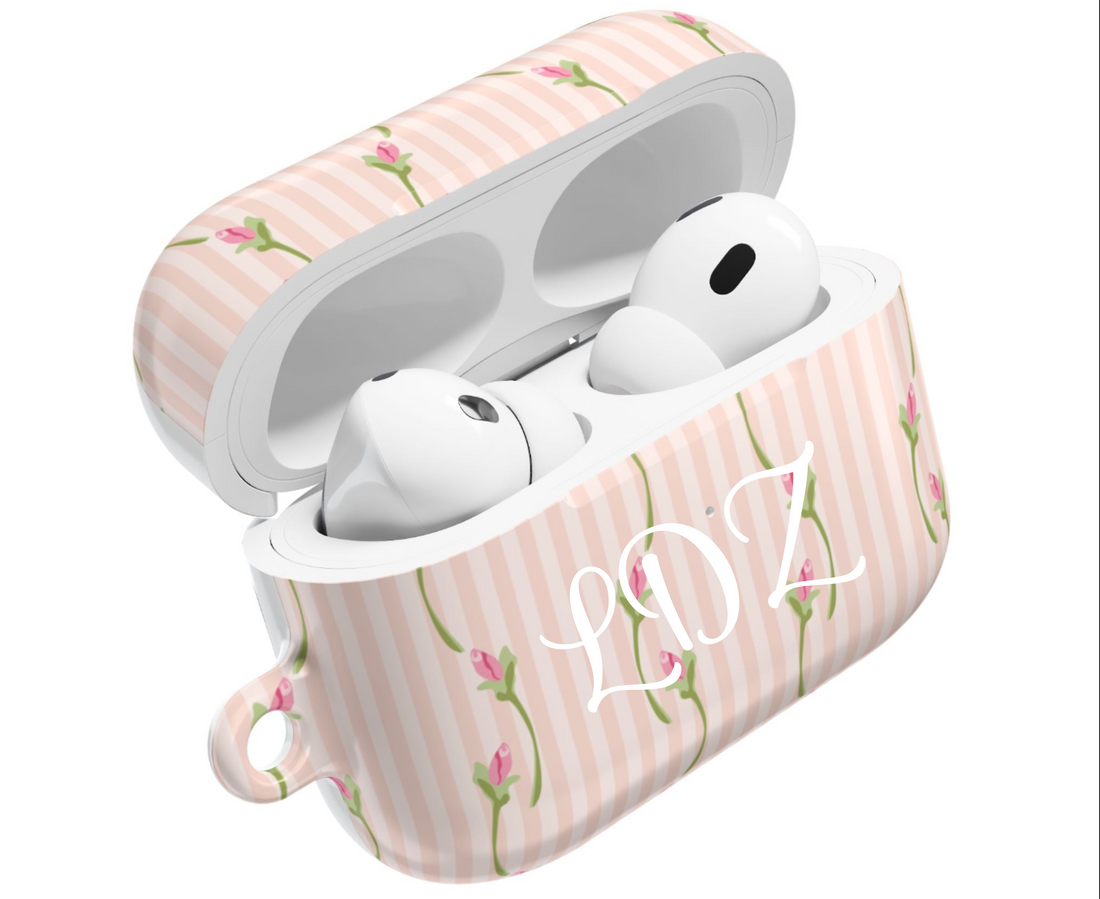 Wireless earbuds in a pink striped case with floral design on a white background