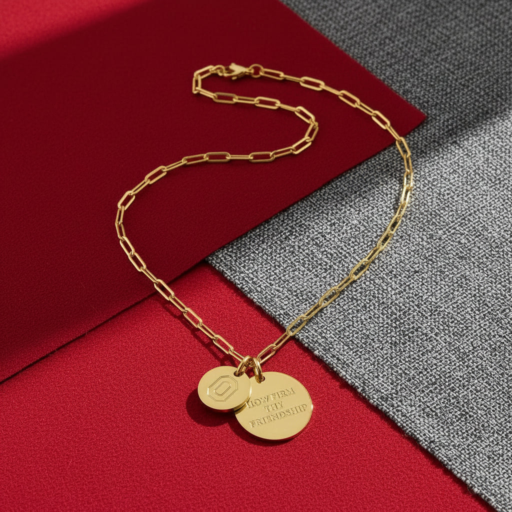 Gold necklace with two round pendants on a white background