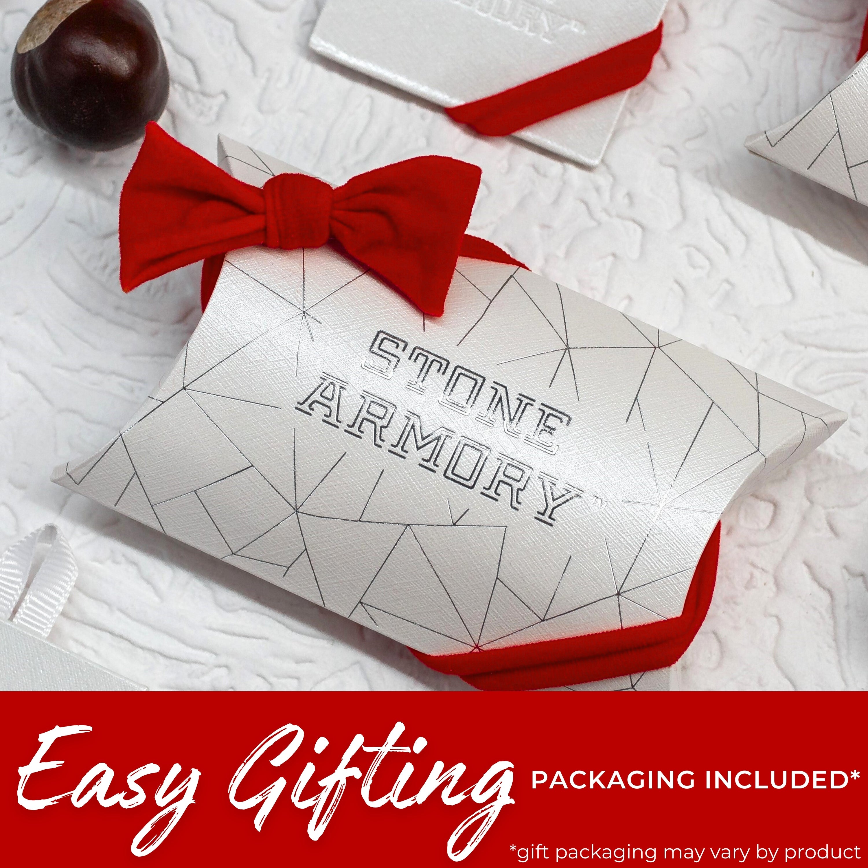 Gift box with red bow and 'Stone Armory' branding on a textured white surface.