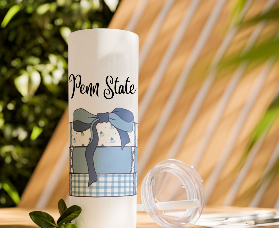 White tumbler with blue book design and a blue coquette bow.