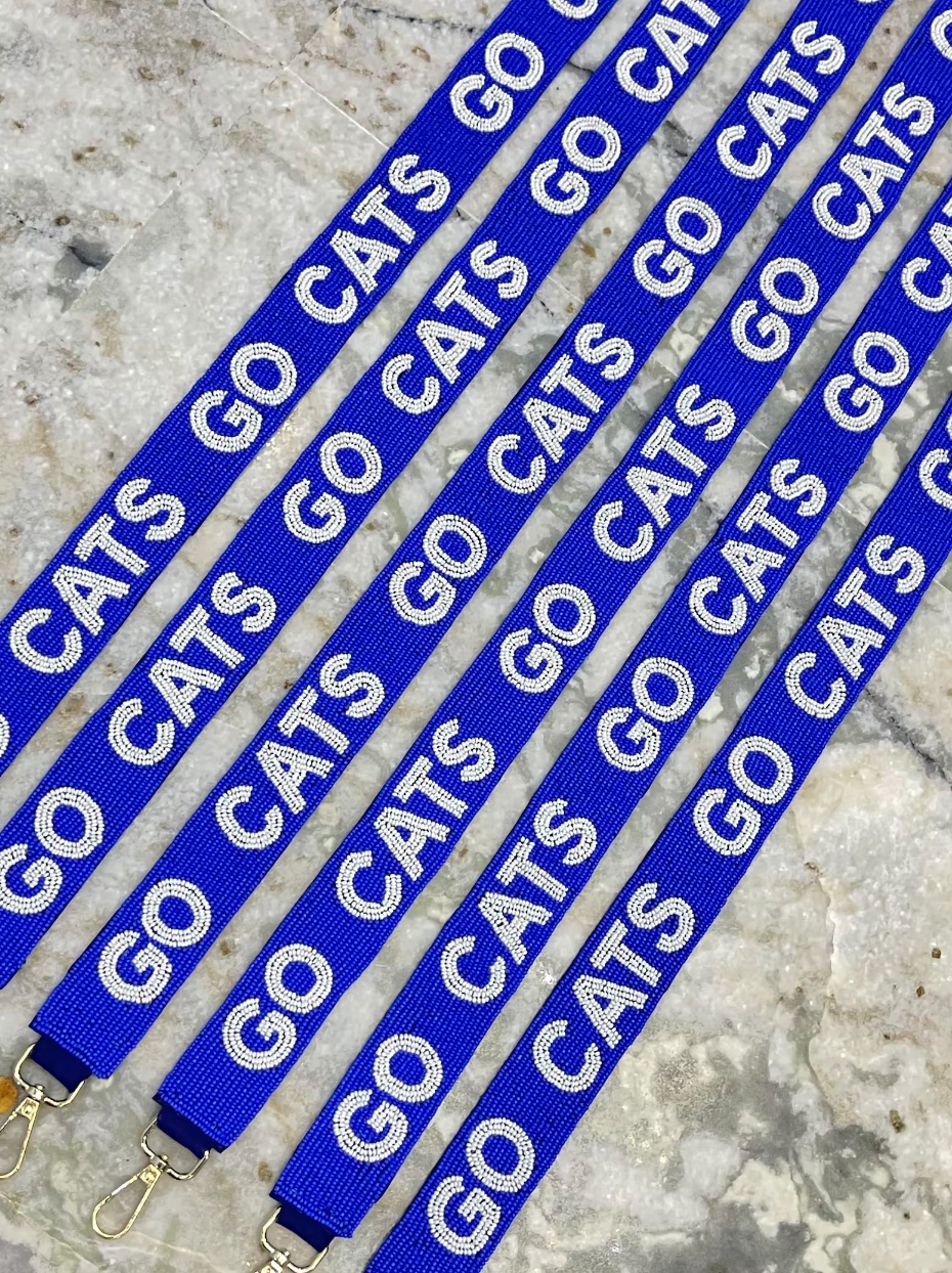 Blue straps with 'GO CATS' text on a beaded surface