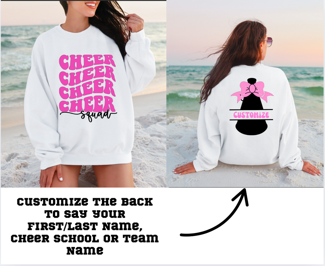 White sweatshirt with pink 'Cheer Squad' text and a customizable back design on a beach.