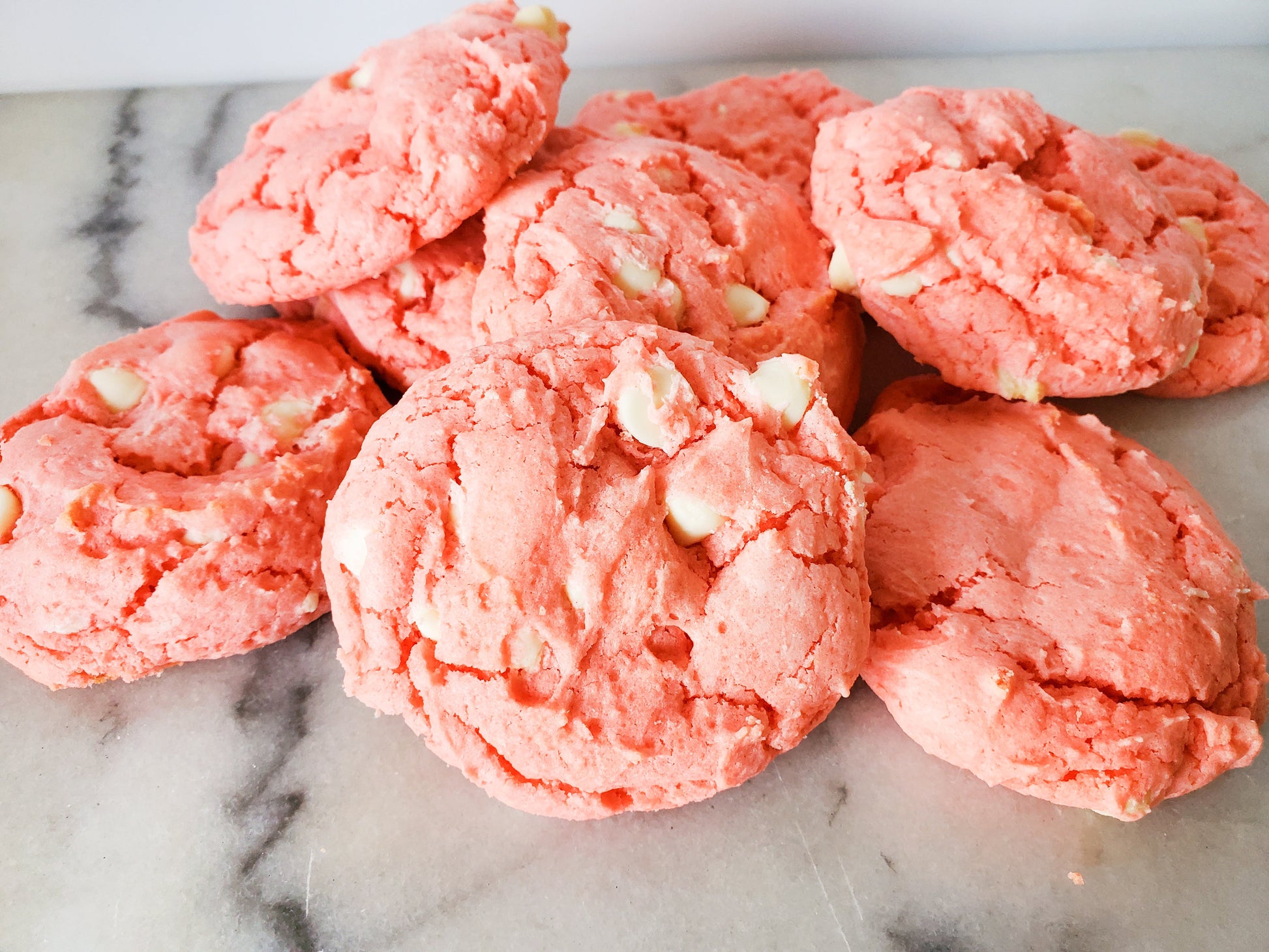 Pink cookies with white chunks on a marble surface