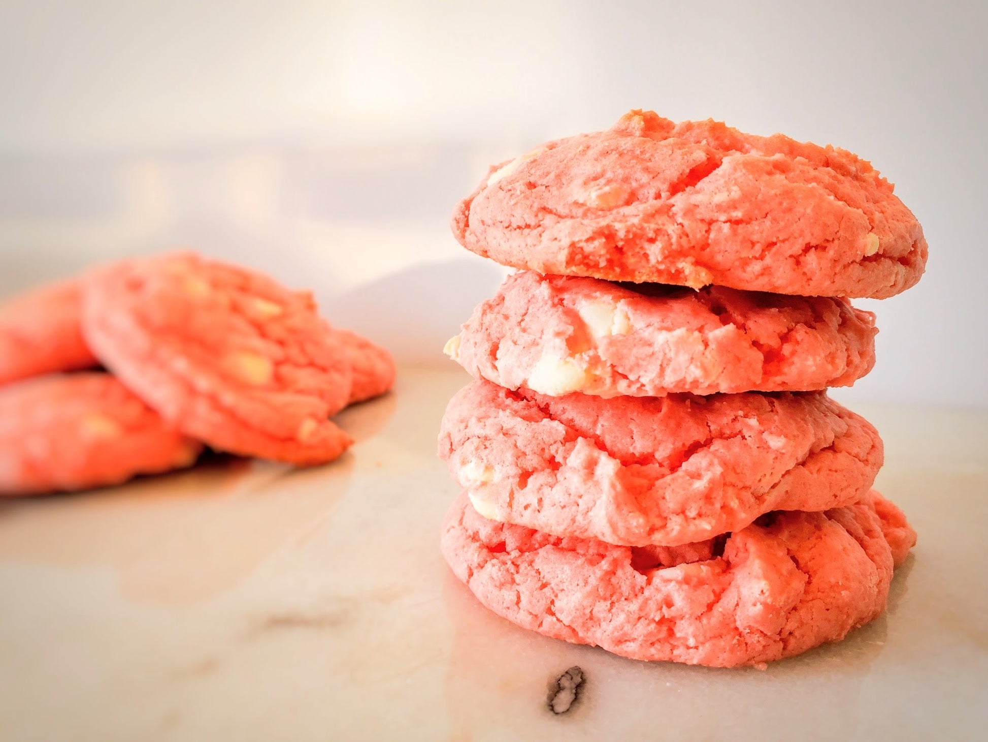 Stack of strawberry cookies on a marble surface with blurred background