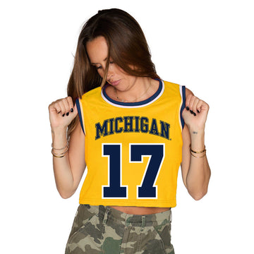 Woman wearing a yellow 'Michigan' tank top with the number 17 on a white background
