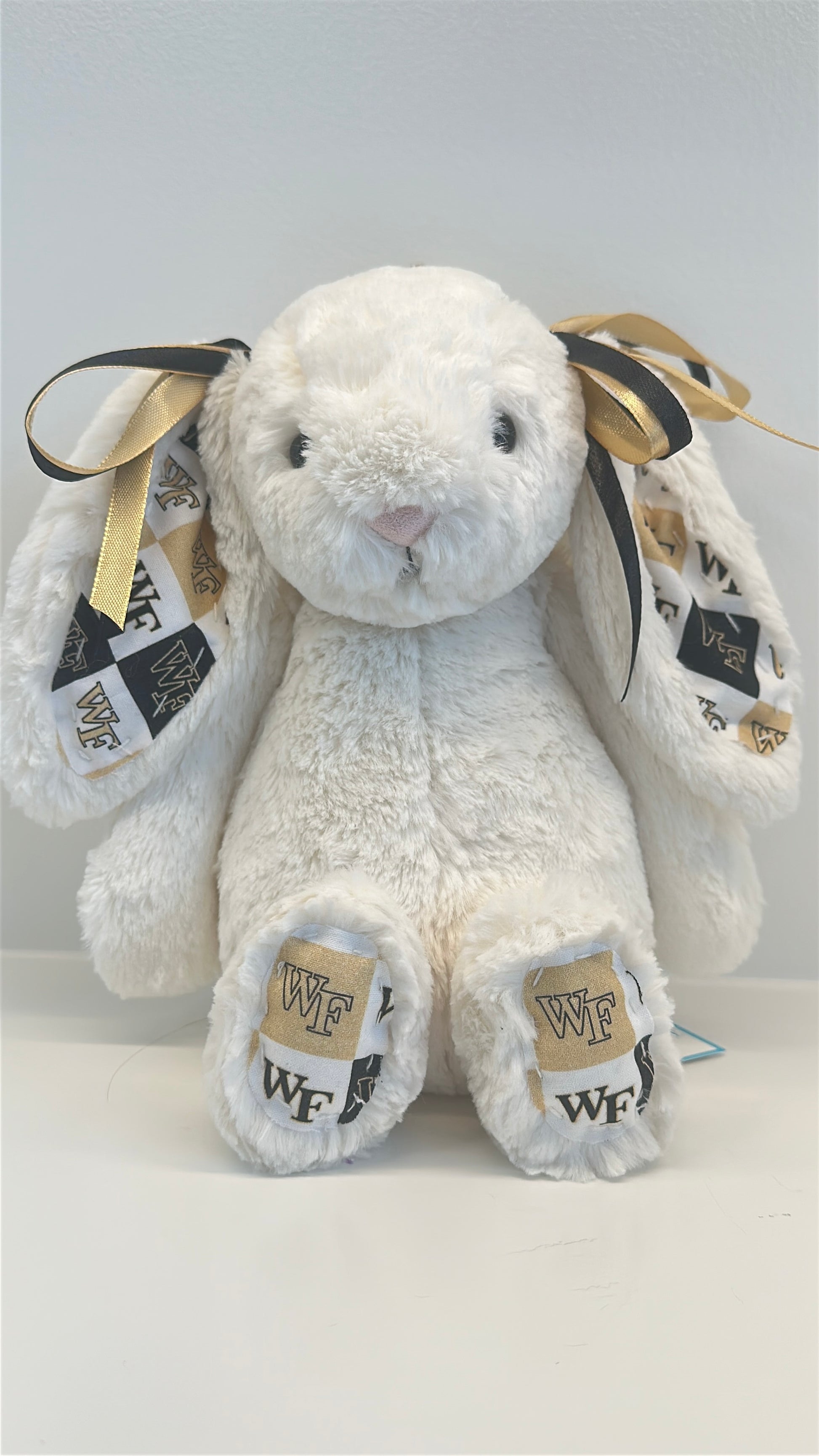 White plush bunny with gold accents and 'WF' branding on a white background