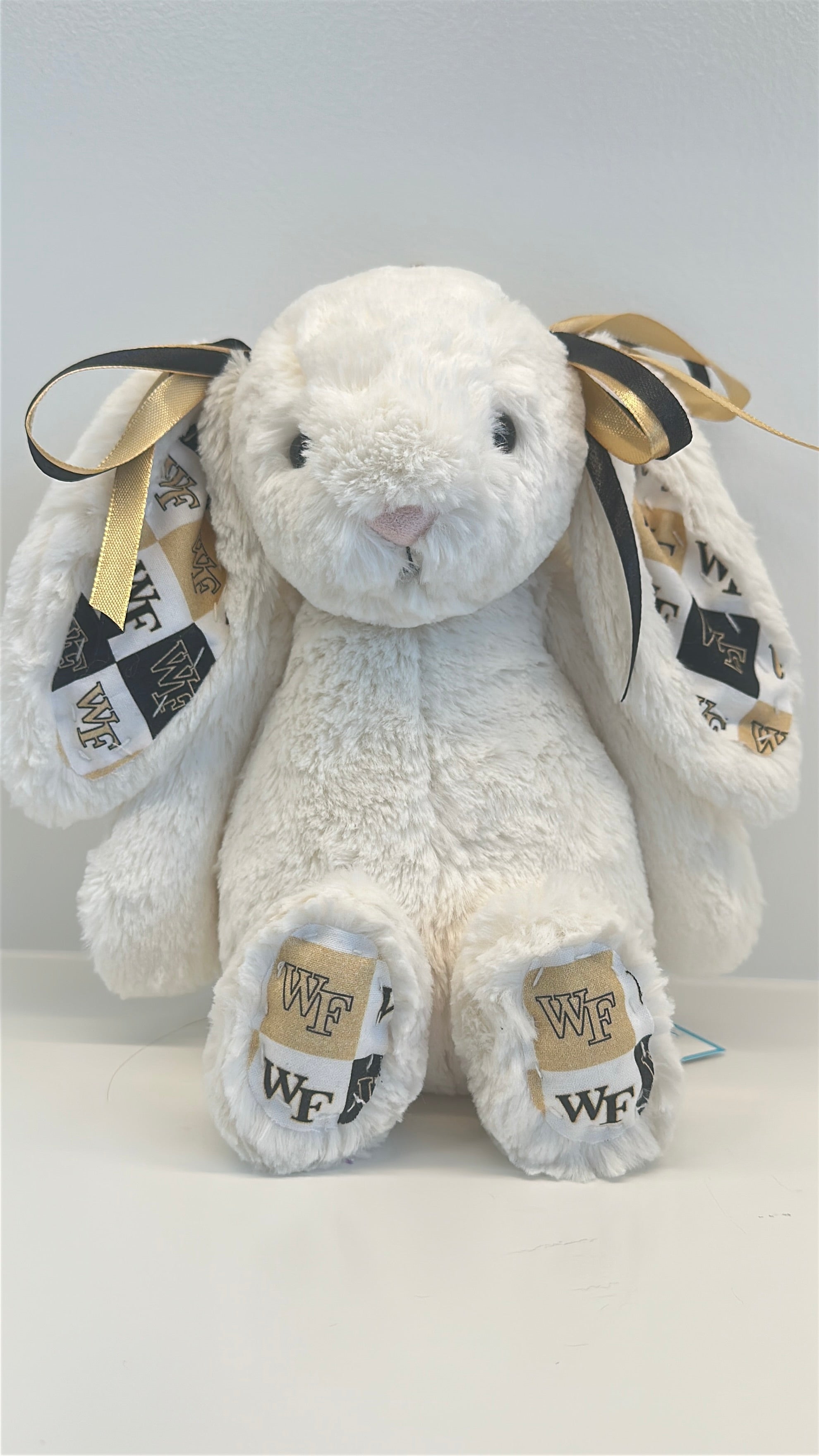White plush bunny with gold accents and 'WF' branding on a white background