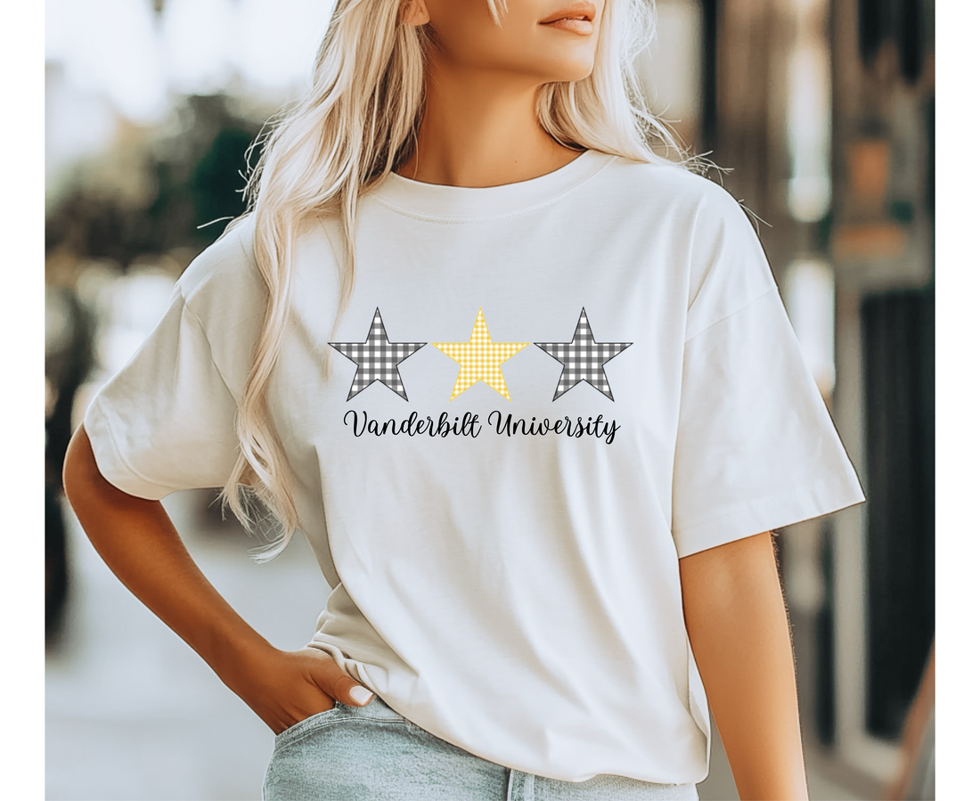 Person wearing a white t-shirt with 3 gingham stars (2 black stars and one gold star) design