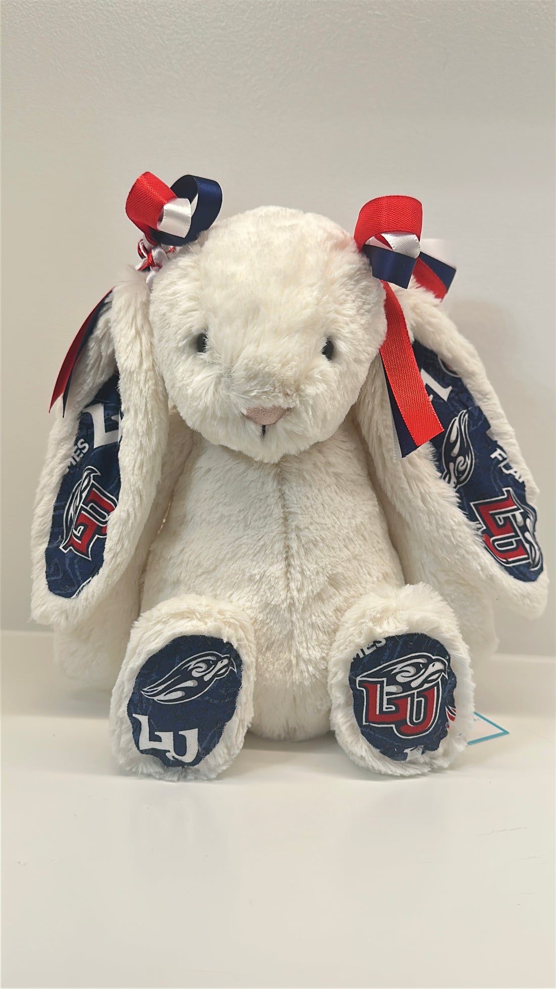 White plush bunny with red, white, and blue accents on a white background