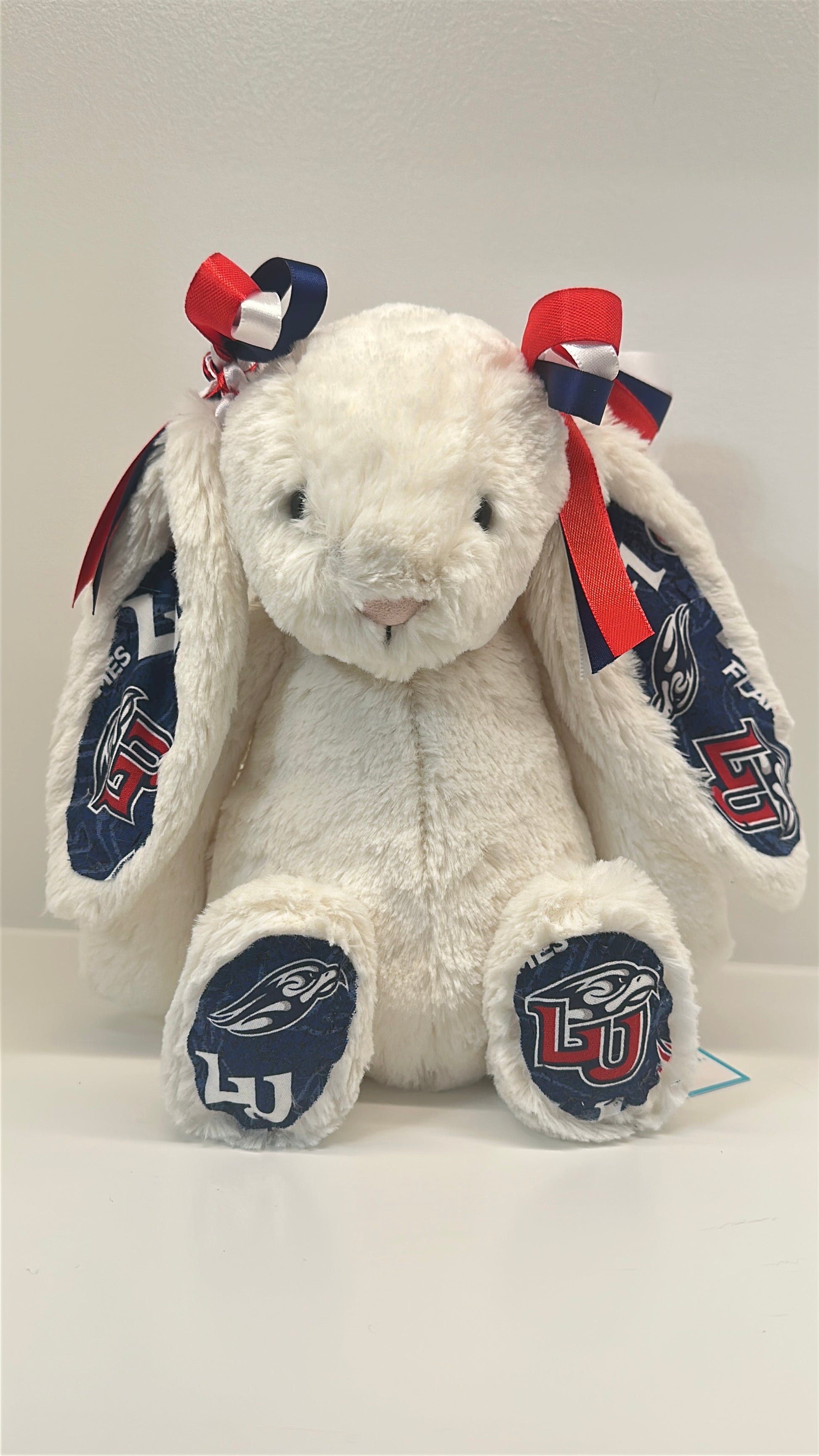 White plush bunny with red, white, and blue accents on a white background