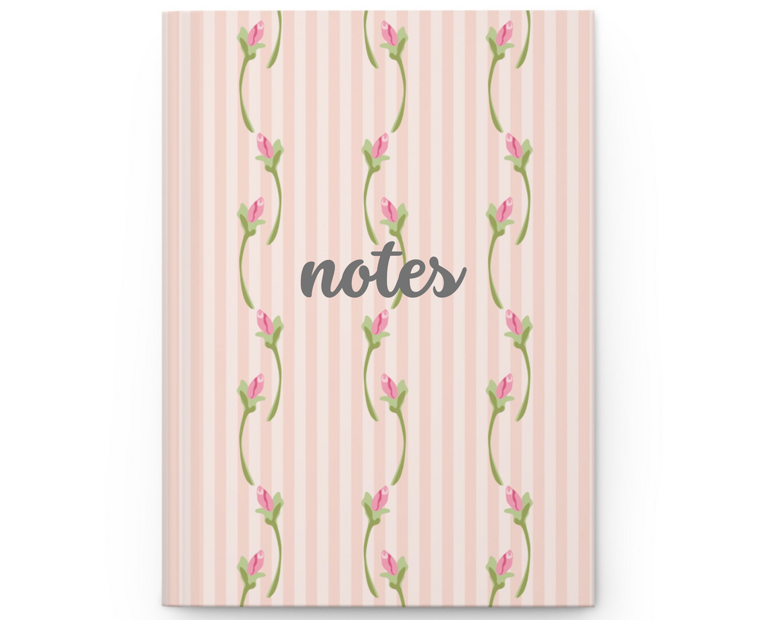Notebook with floral design on a pink striped background